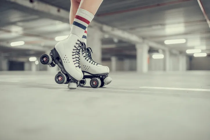 young woman rollerskating in an urban looking garage and posing in a hipster like matter